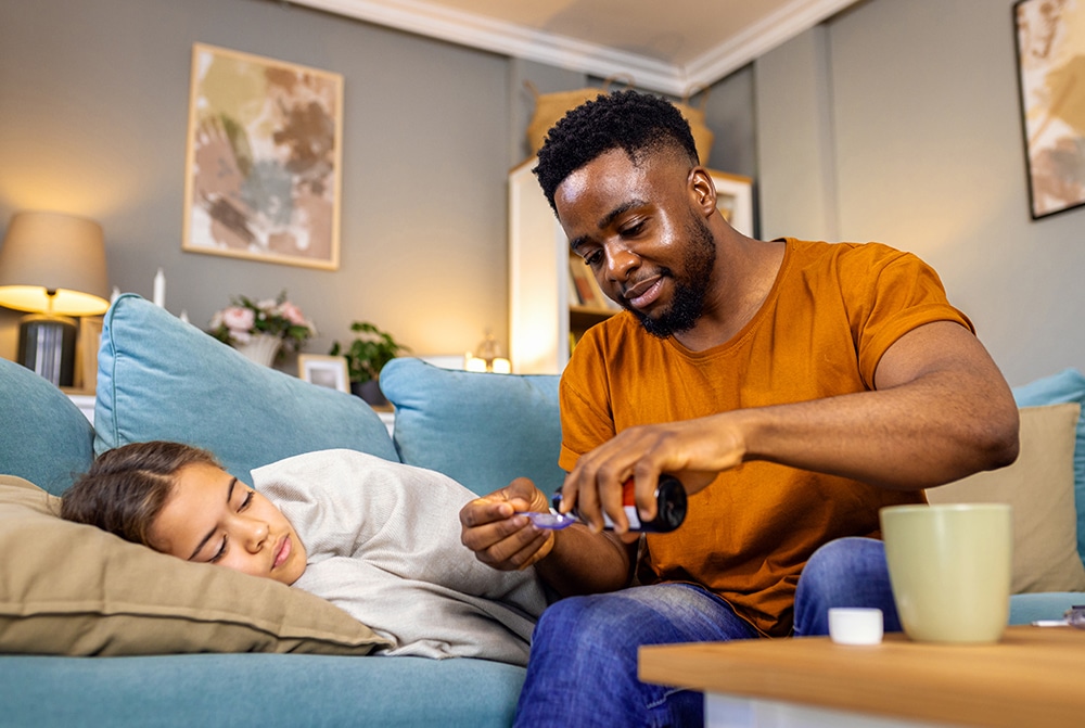 African American father takes care of his sick daughter at home